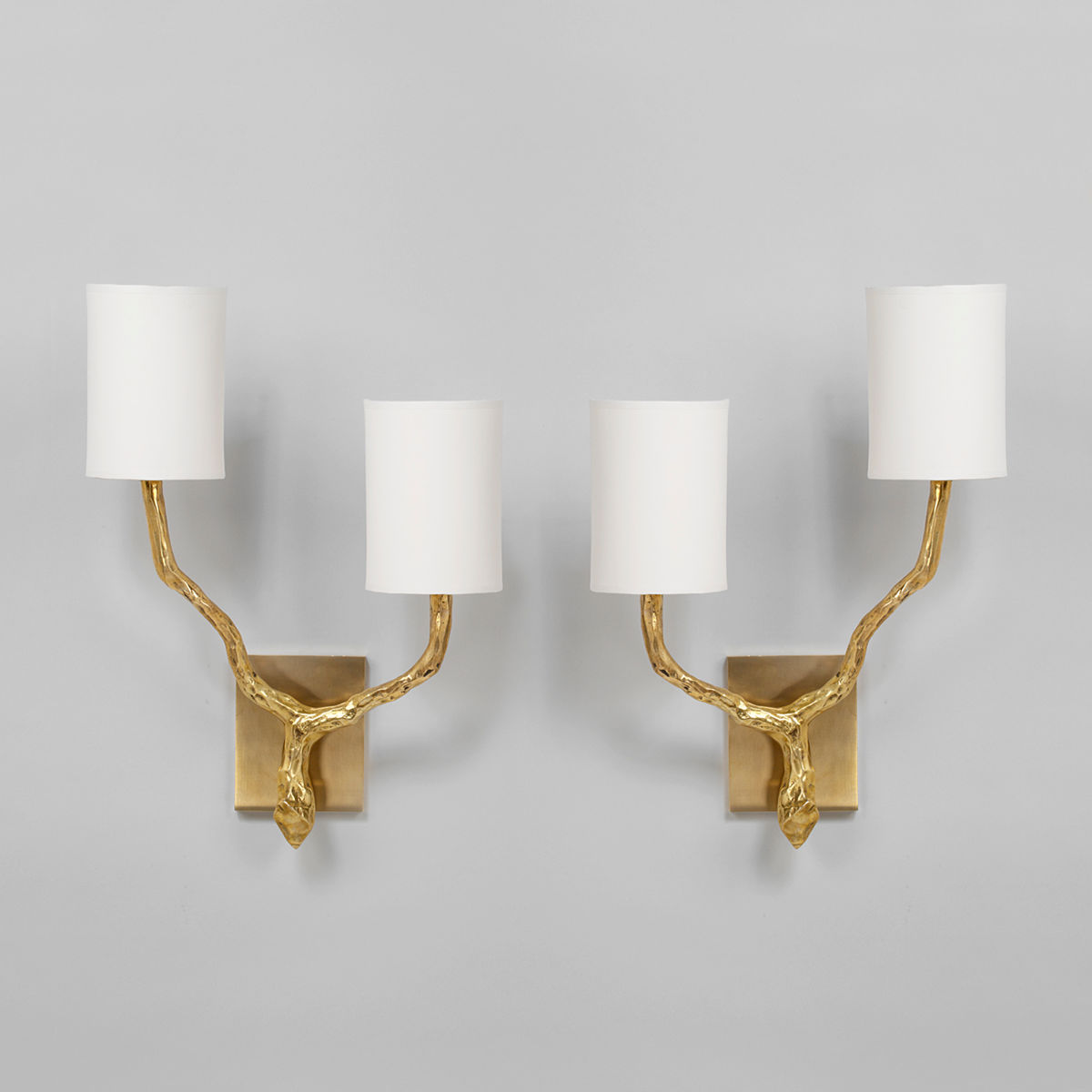 Cylindrical cream lampshades on brass wall lights
