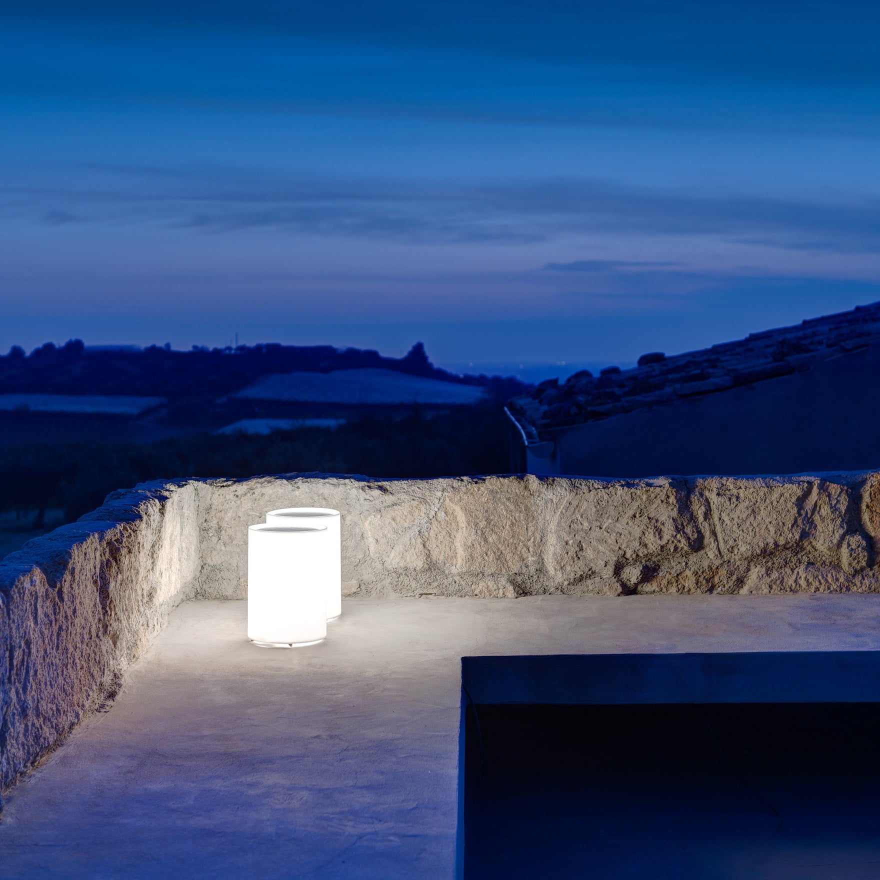 Lenta outdoor lights against stone wall with landscape view