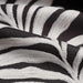 detail of embroidered fabric in charcoal and cream of leaves in stripe pattern