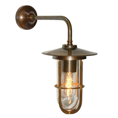 Antique brass outdoor wall light fixture with clear glass cover on a white background