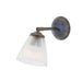 Wall-mounted light fixture in antique brass with prismatic glass shade on a white background