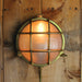 Round wall light fixture with glass cover on a wooden wall