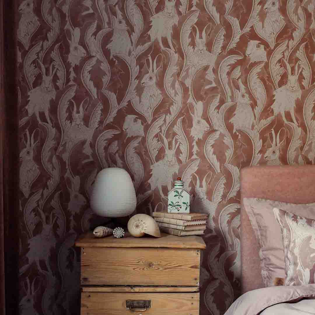 Bedroom with patterned wallpaper and wooden nightstand