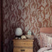 Bedroom with patterned wallpaper and wooden nightstand