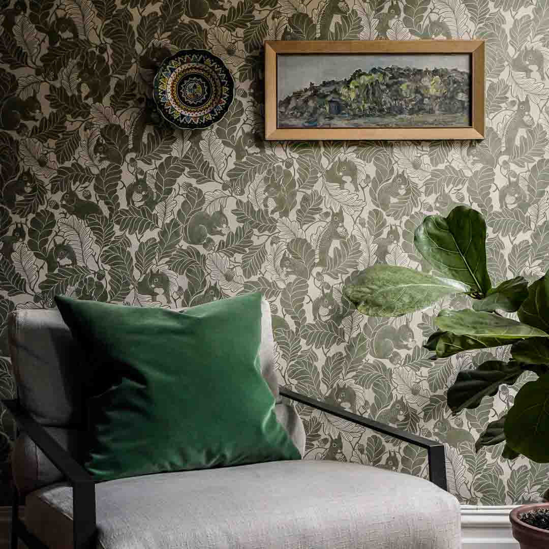Living room with patterned wallpaper, green cushion, and framed picture.