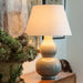 Cream Linen Laminated Lampshade and crackled Vase Lamp  on console with picture and plant
