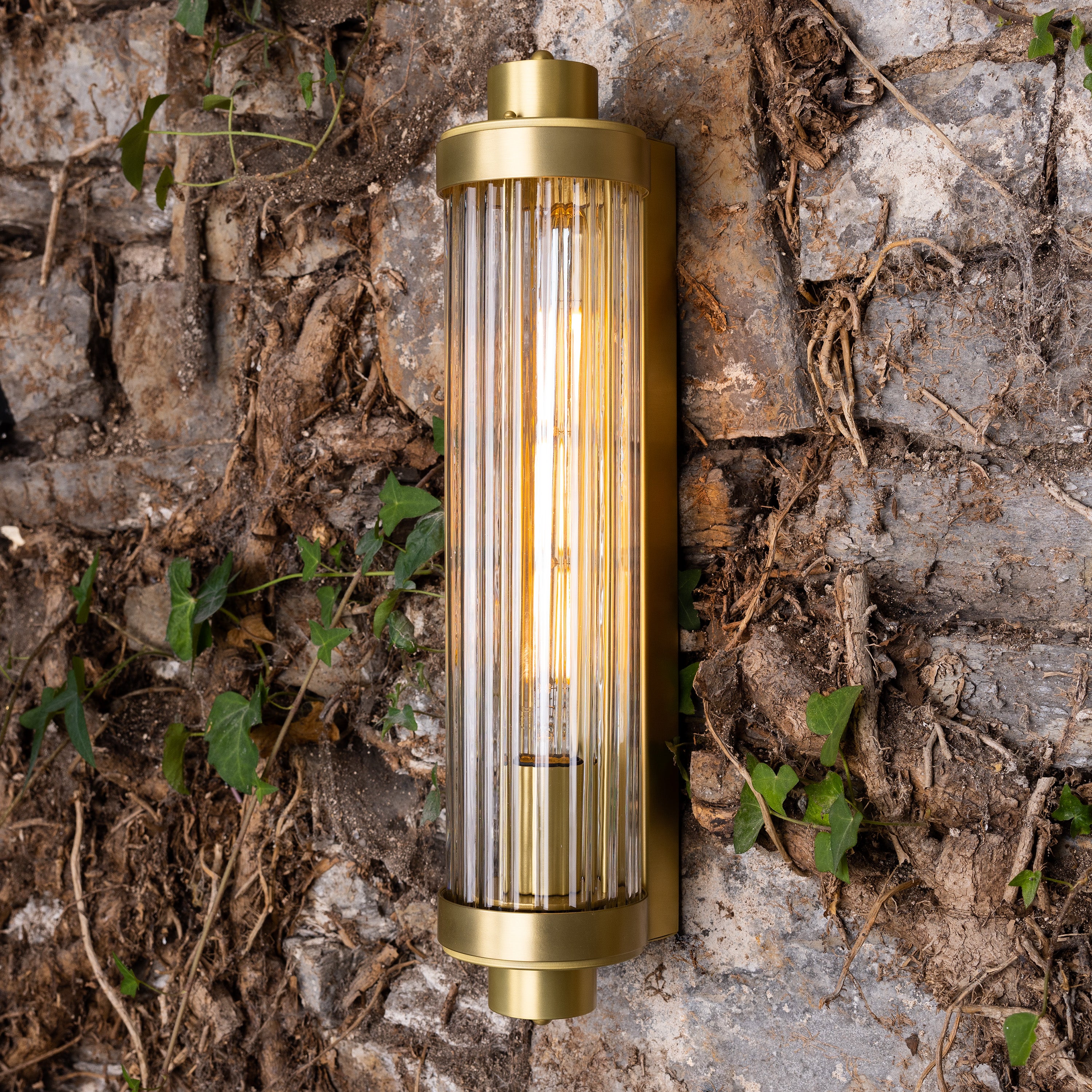 Retro Bathroom wall light fixture in Satin Brass on a rustic wall