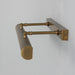 Brass wall-mounted lamp with cylindrical shade on a light gray background