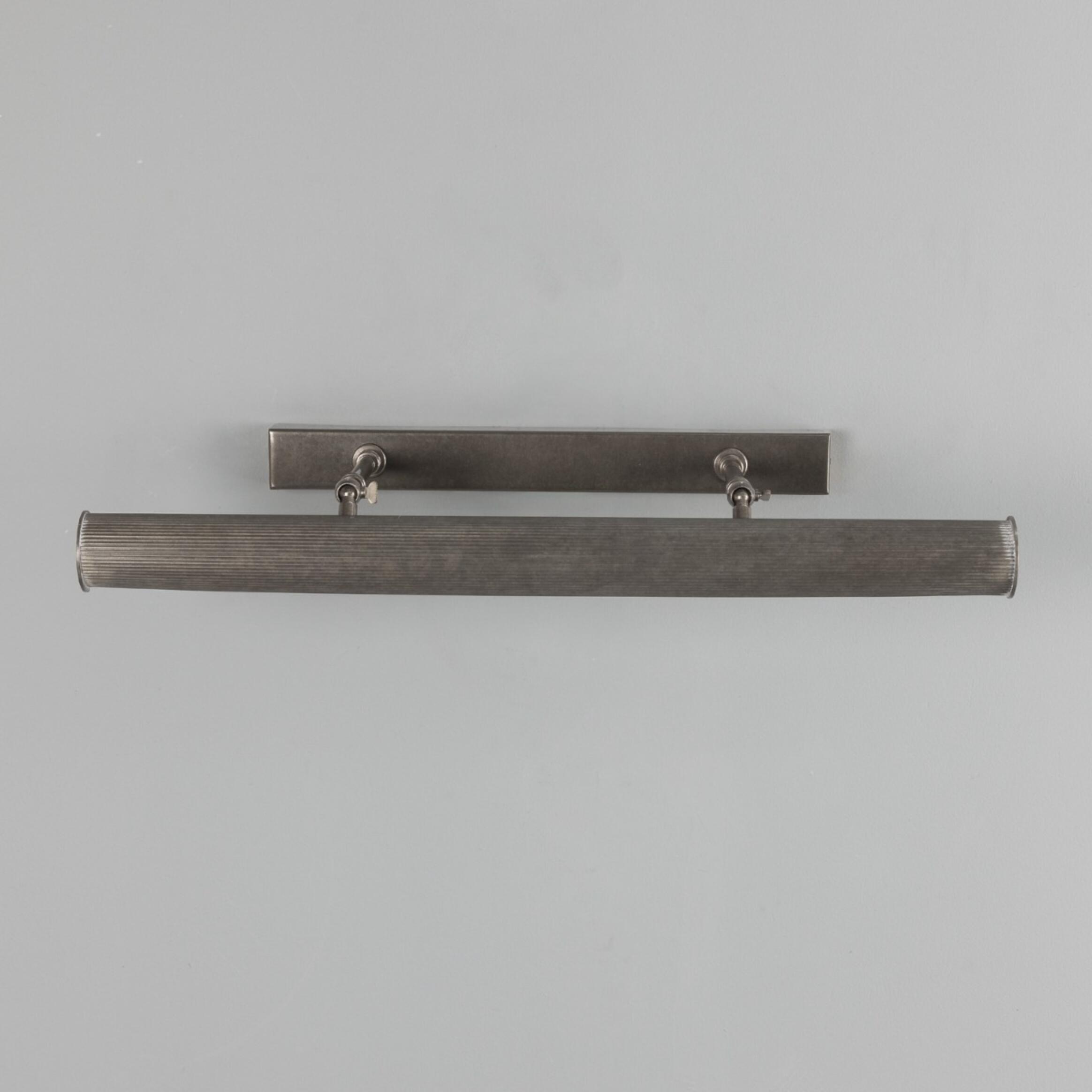 Metallic wall-mounted light fixture on a gray background