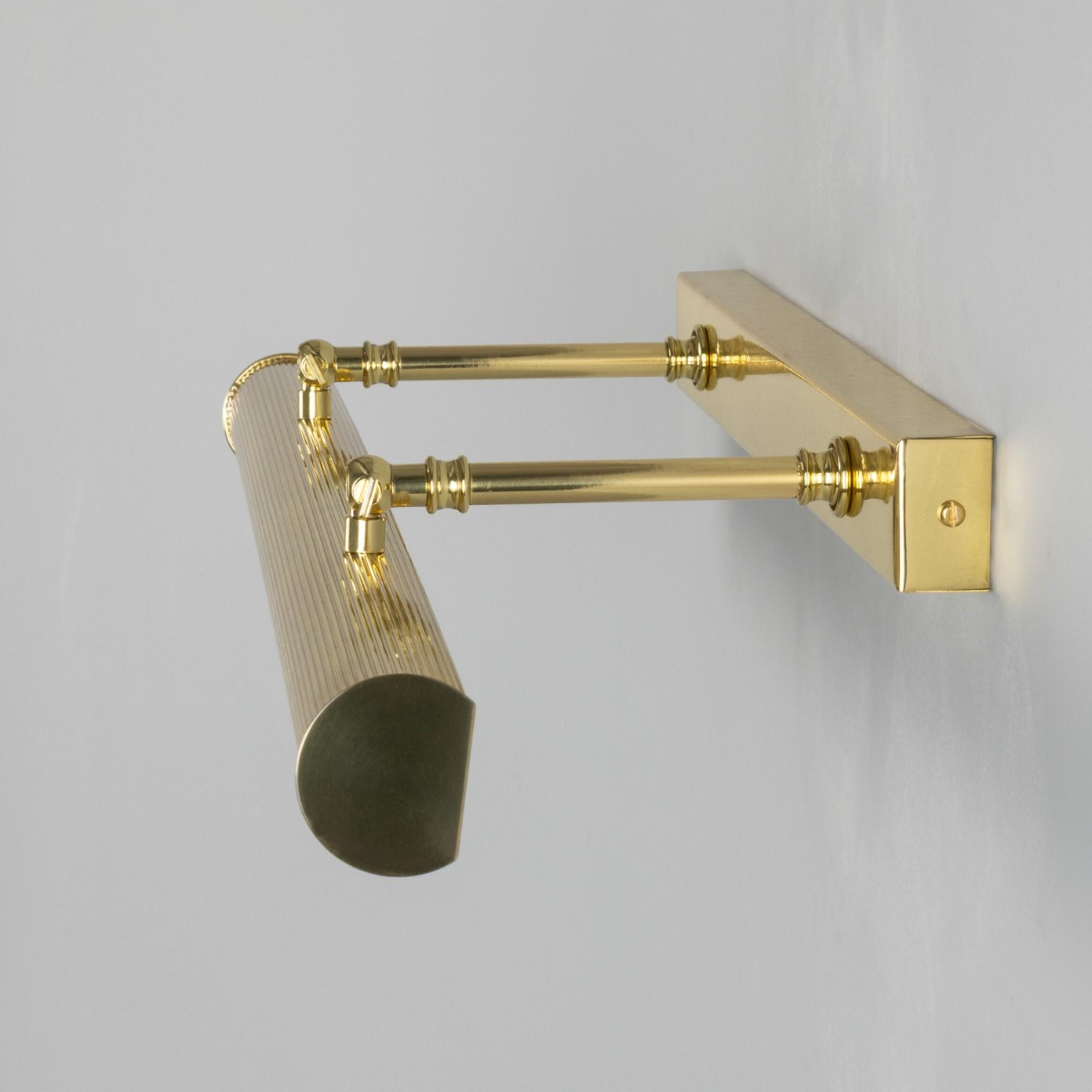 Brasswall-mounted lamp with a grey background